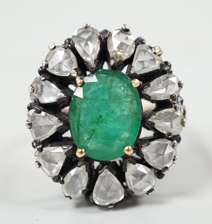 An Indian yellow and white metal, emerald and rose cut diamond set oval cluster dress ring, size N, gross weight 6.3 grams.